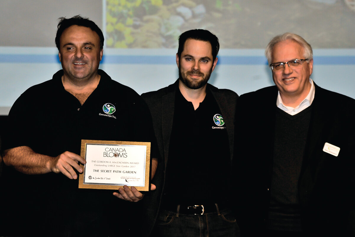 three men on stage with an award