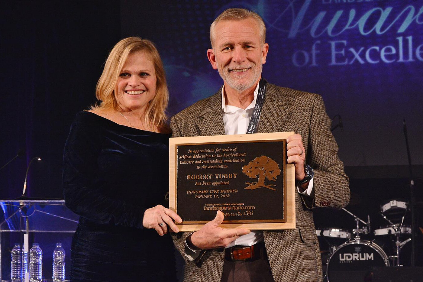 Bob Tubby accepting an award with his wife Mitzi beside him.