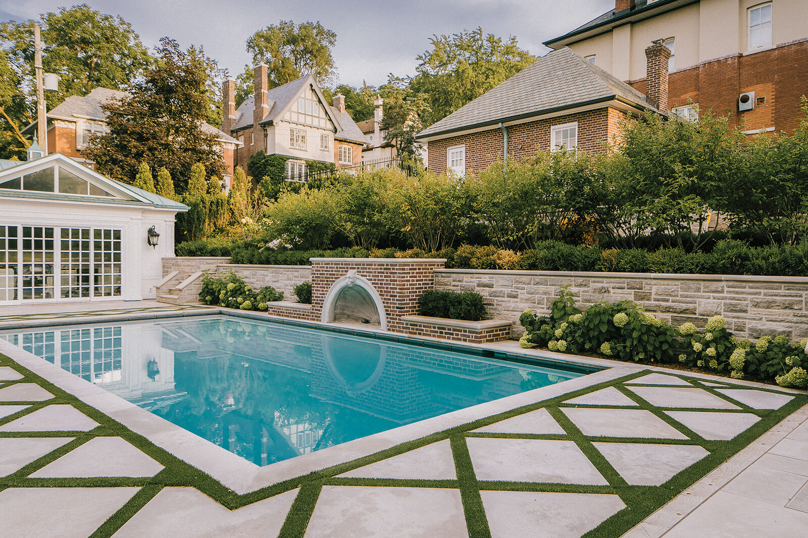 backyard with a pool and stone wall