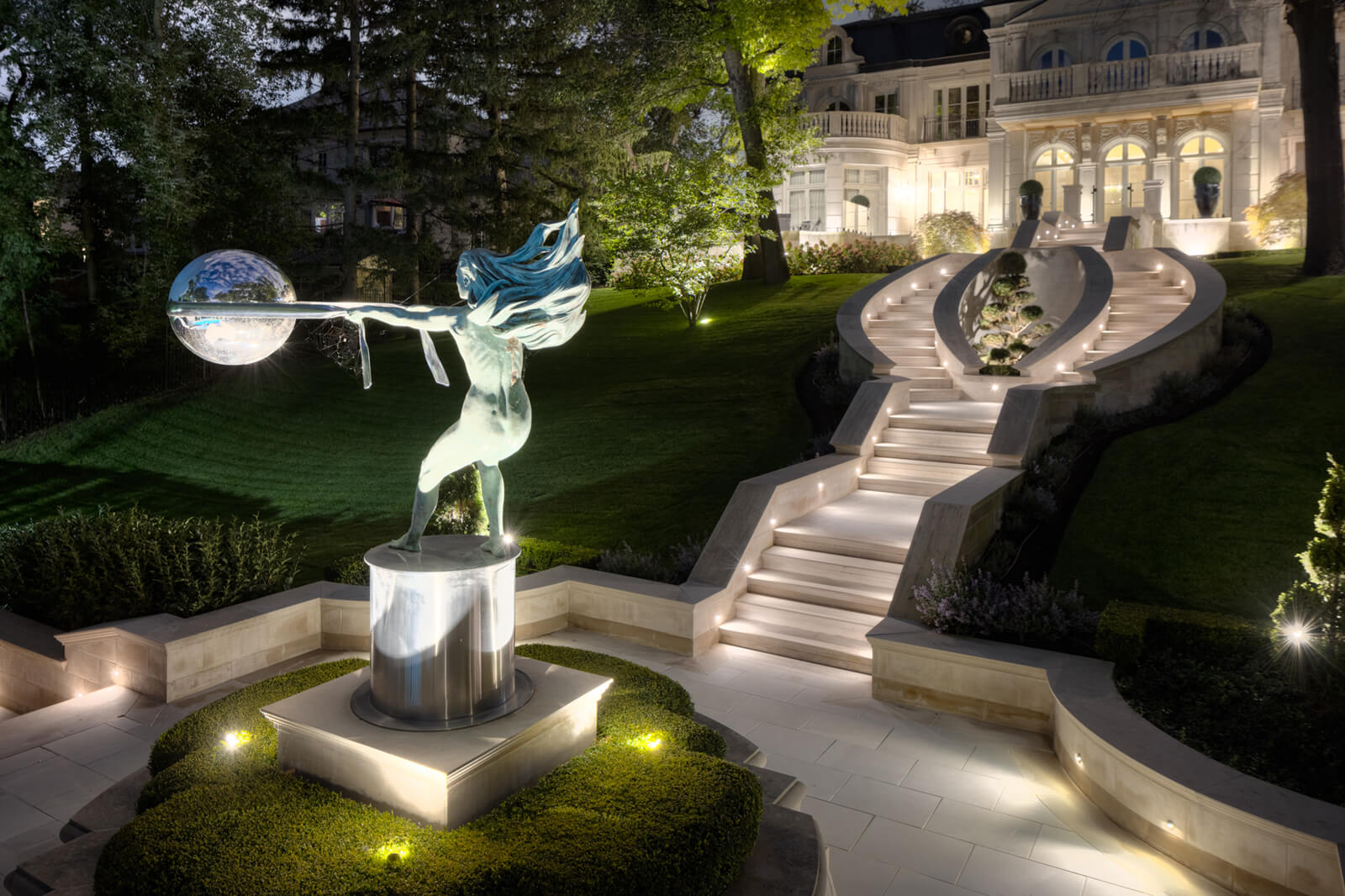 a stone statue in a backyard landscape